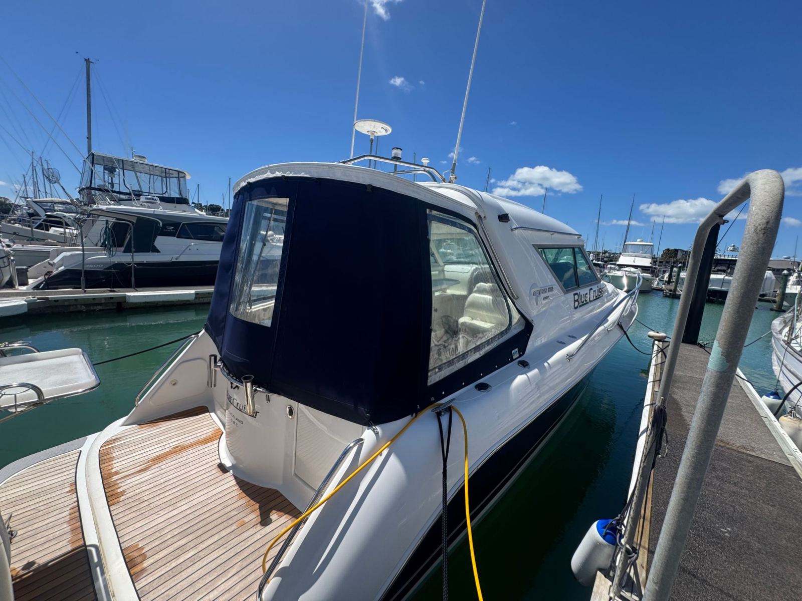 Hardtop cruiser with teak cockpit at the marina