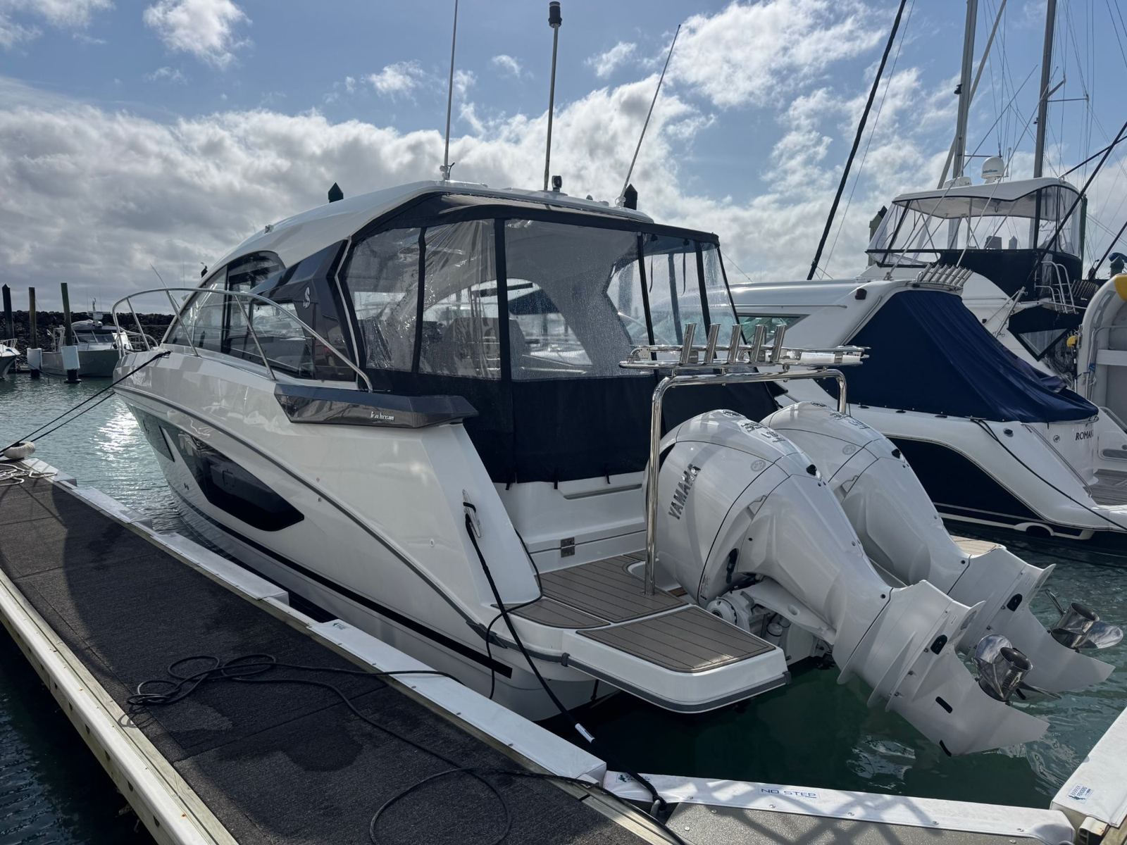 Sport cruiser with twin outboards at its berth