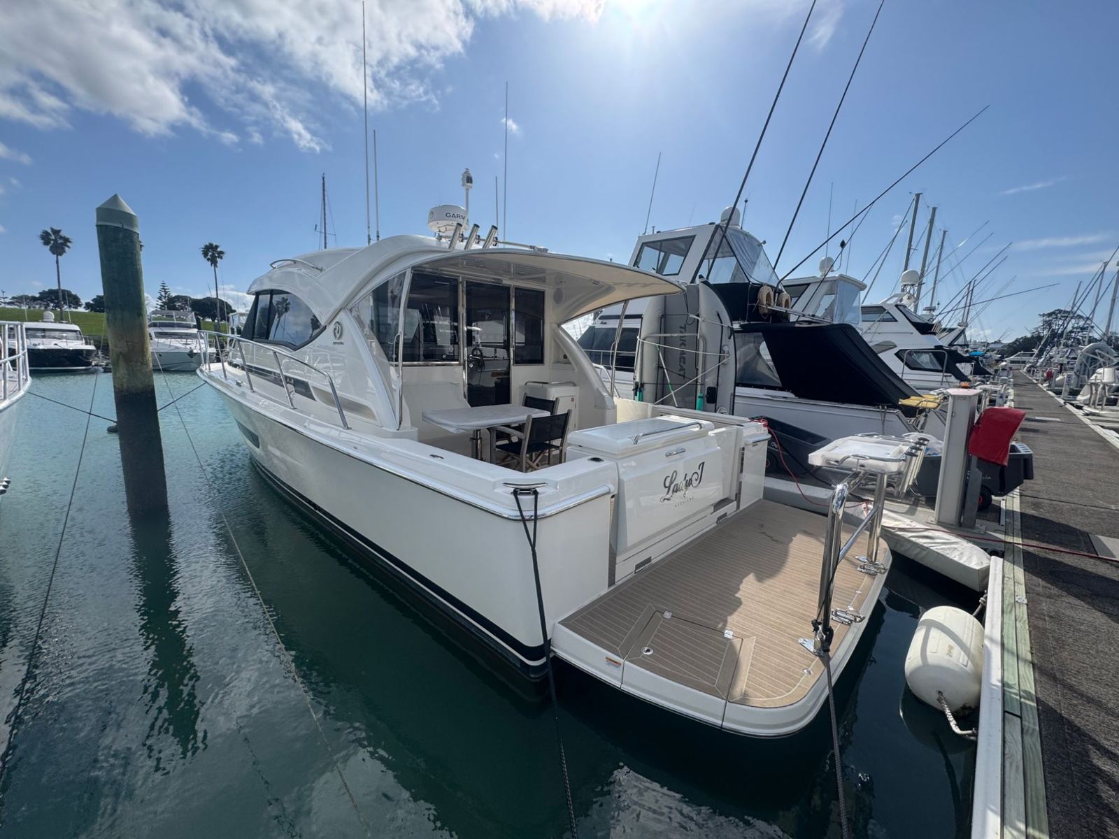 Launch at a marina berth with clean teak swim platform